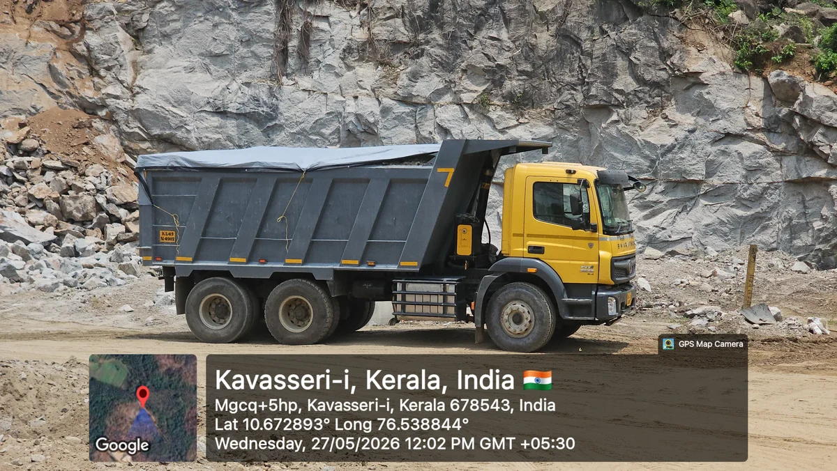Yellow tipper truck loaded with granite building stones at the quarry face